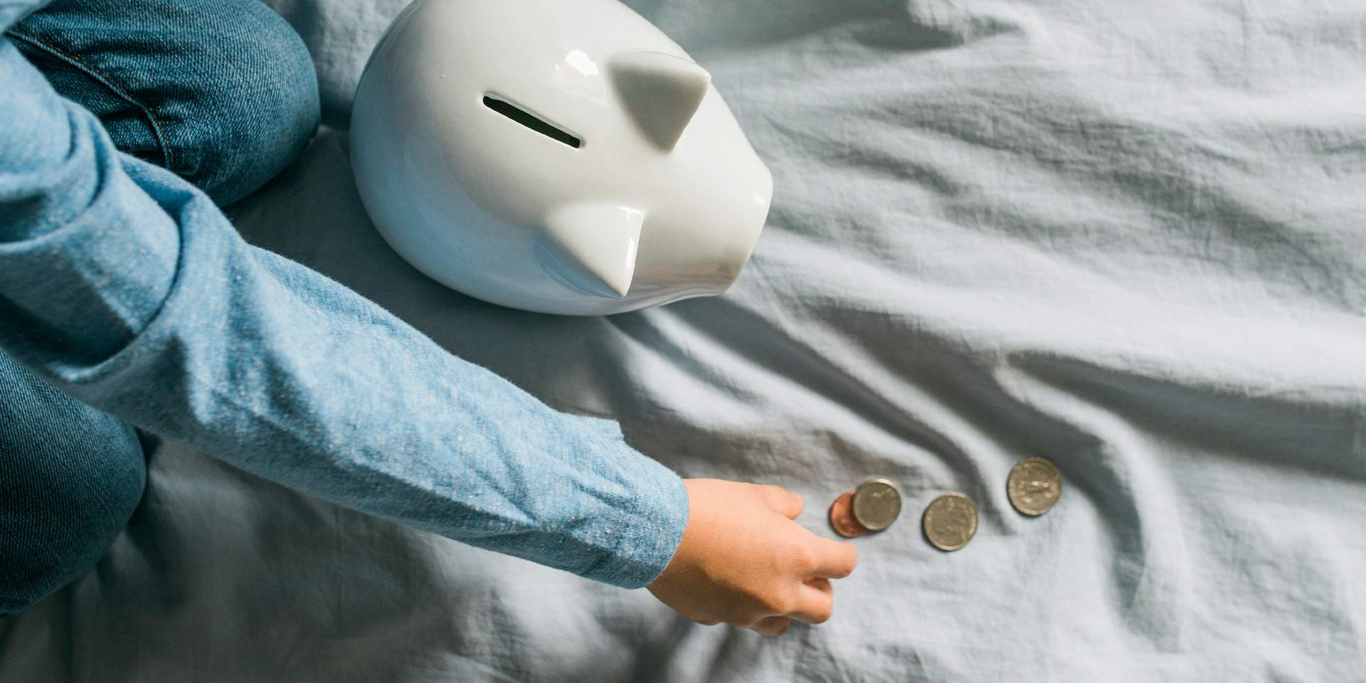 Child gathers money to put it into a money box.