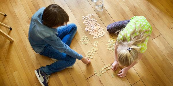 Boy and girl counting money on the floor