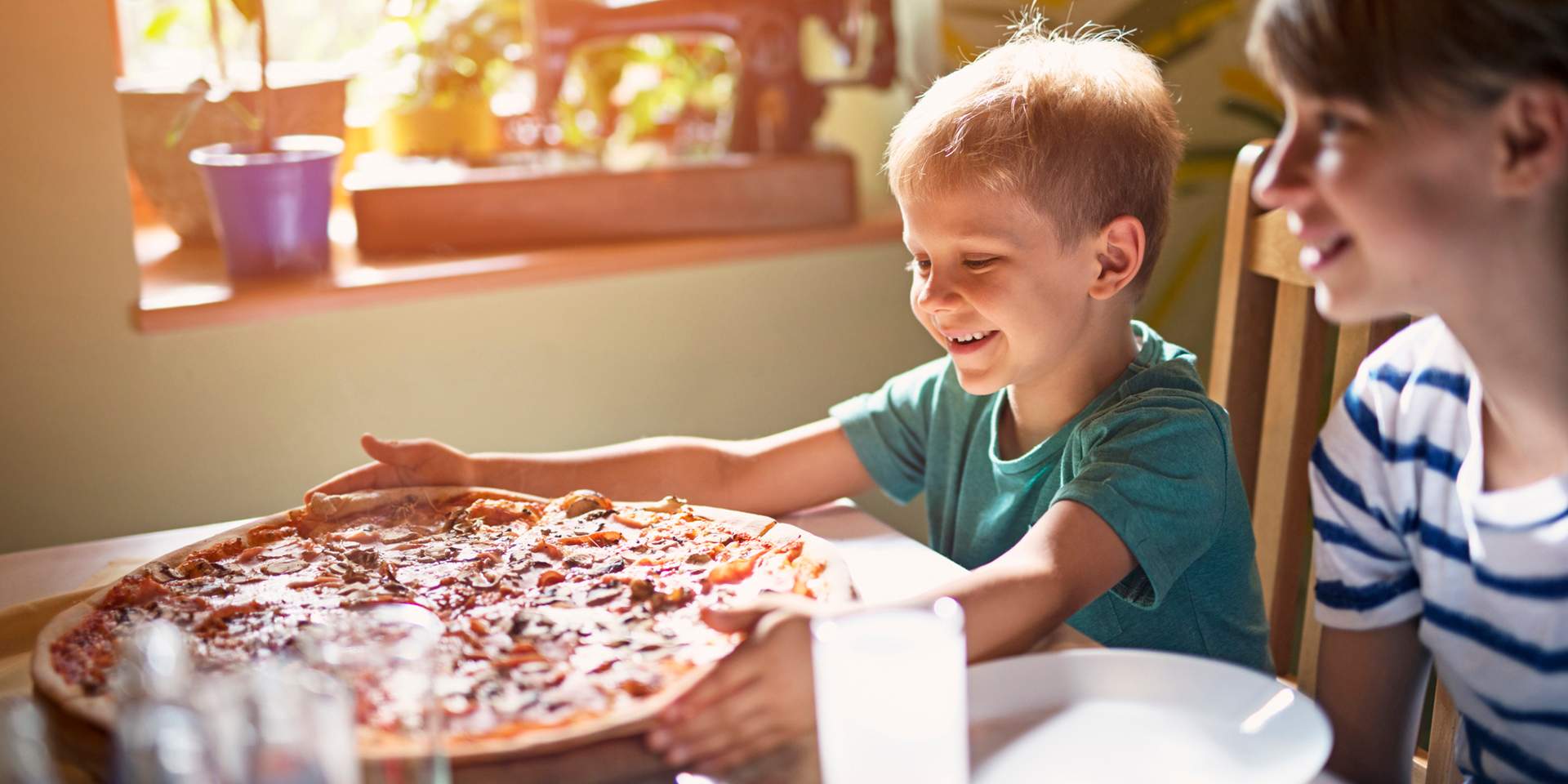 Child reaches for pizza